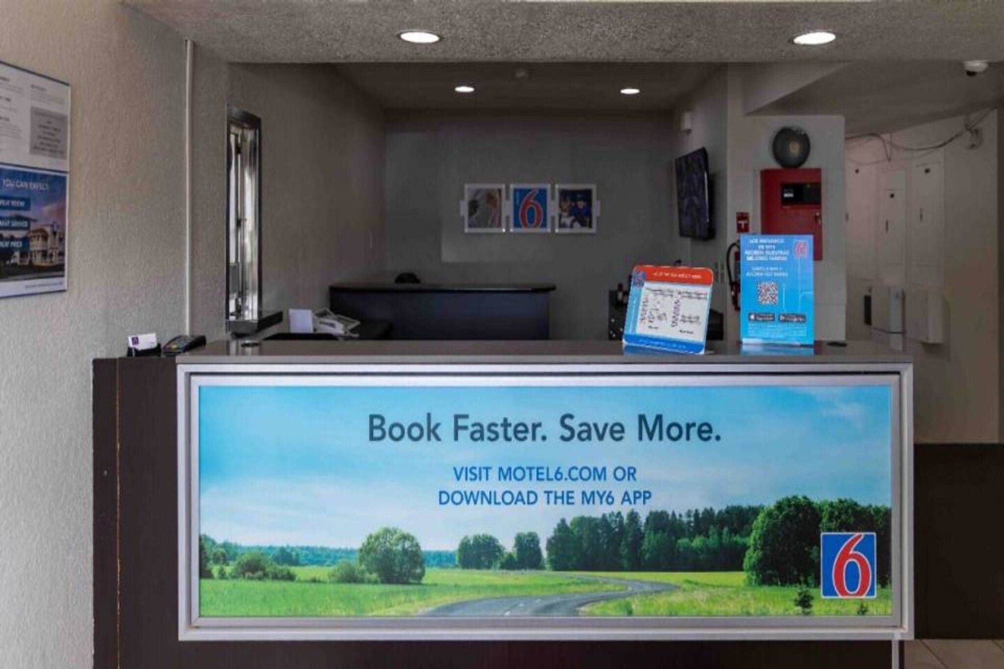 A reception desk with a digital screen displaying a booking message.