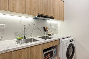 A kitchen with a built-in microwave, a sink, and wooden cabinets. - 8 Nguyen Van Ngoc (BA DINH)