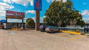 Un motel appelé « Boot Barn », avec une grande enseigne bleue, un parking et quelques voitures garées.