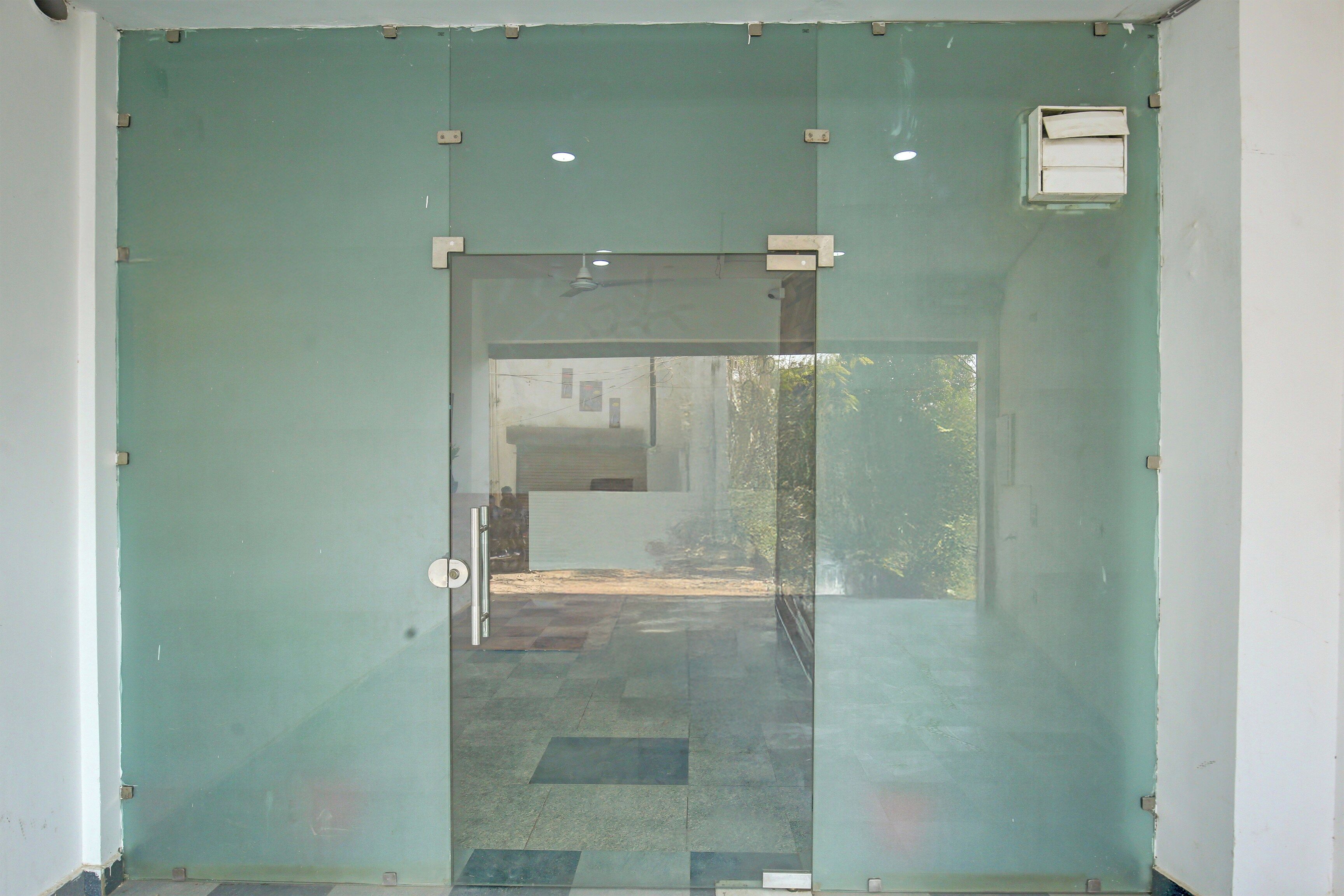 A glass door with a metal handle and a small rectangular window on the upper right.