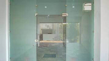 A glass door with a metal handle and a small rectangular window on the upper right.