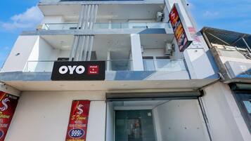 A hotel with a sign indicating 'OYO Town Hotel' and 'Luxury Rooms Available'.