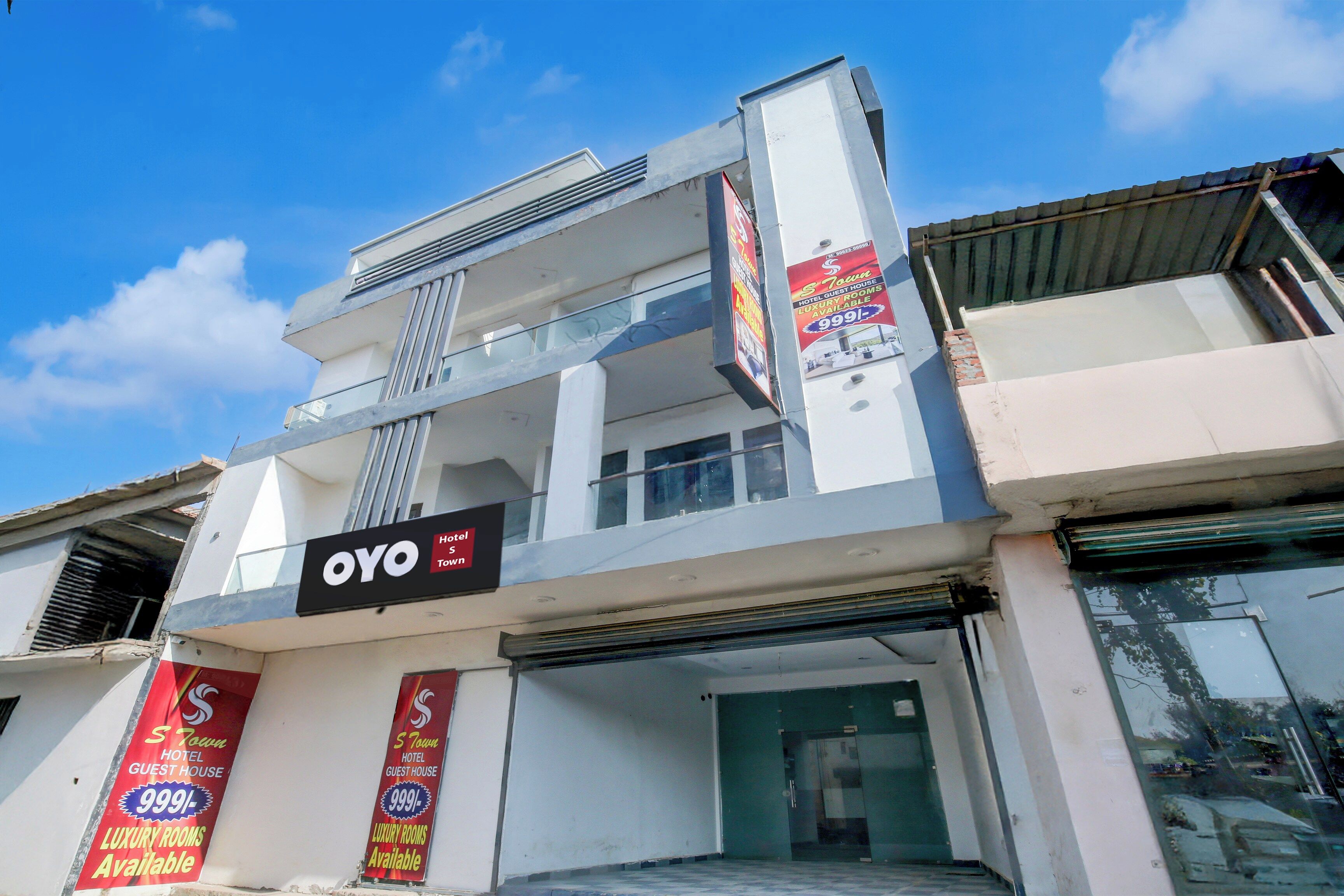 A hotel with a signboard for 'OYO Hotel' and multiple banners advertising 'Luxury Rooms Available'.