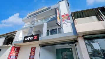 A hotel with a signboard for 'OYO Hotel' and multiple banners advertising 'Luxury Rooms Available'.