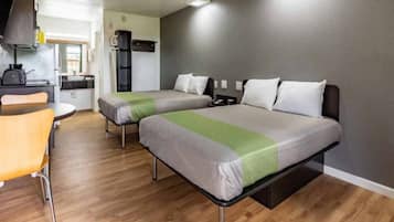 Une chambre avec deux lits, une petite kitchenette et un coin repas.