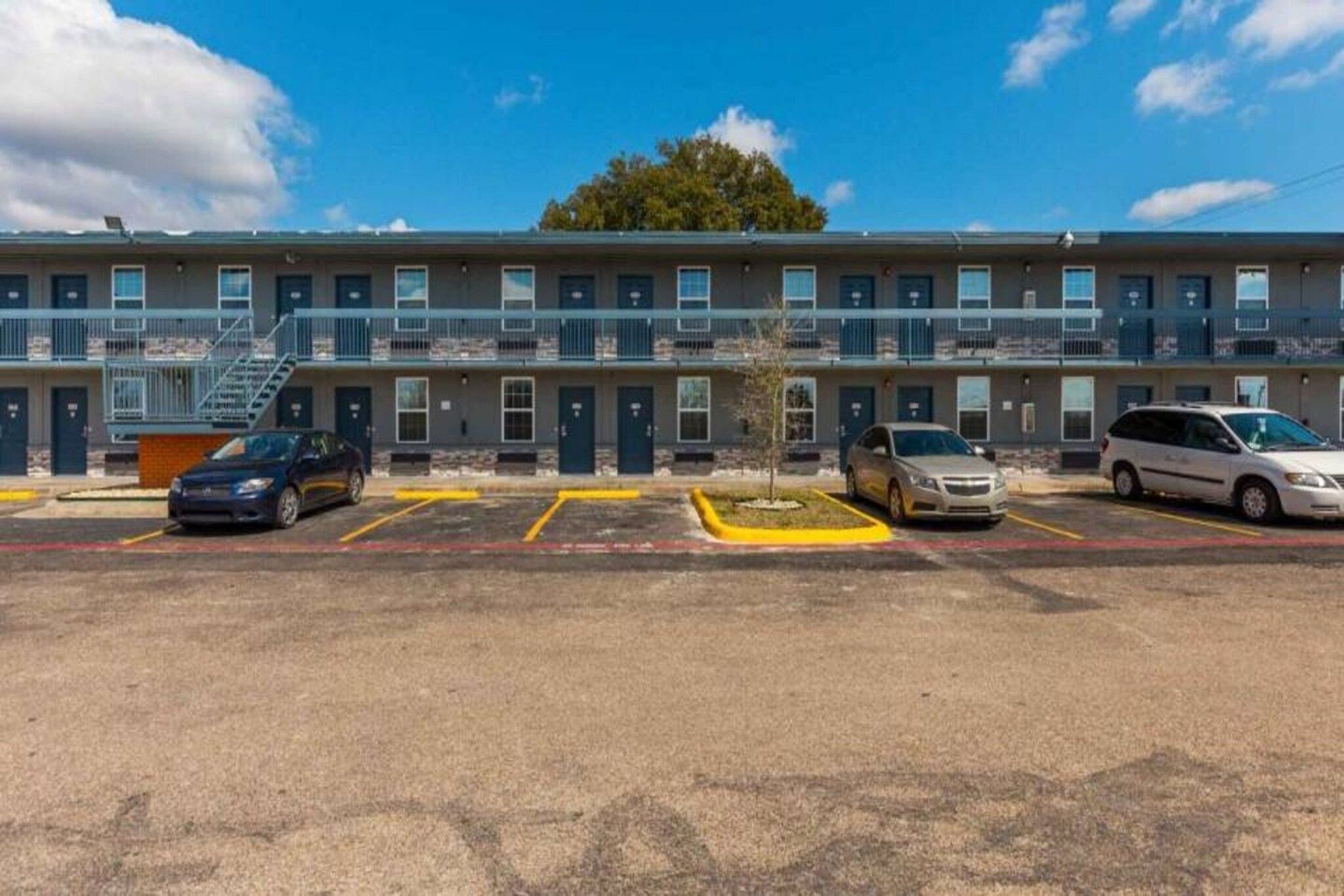 A multi-story motel with a parking lot.