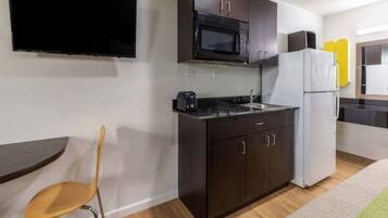 A compact kitchen with a microwave, stove, and refrigerator.