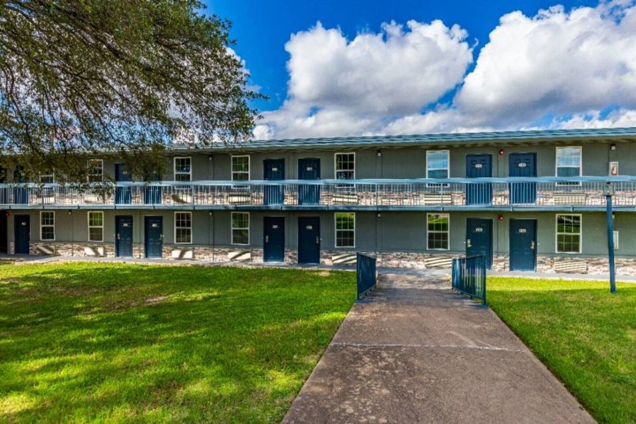 A two-story motel with a central walkway leading to the entrance.