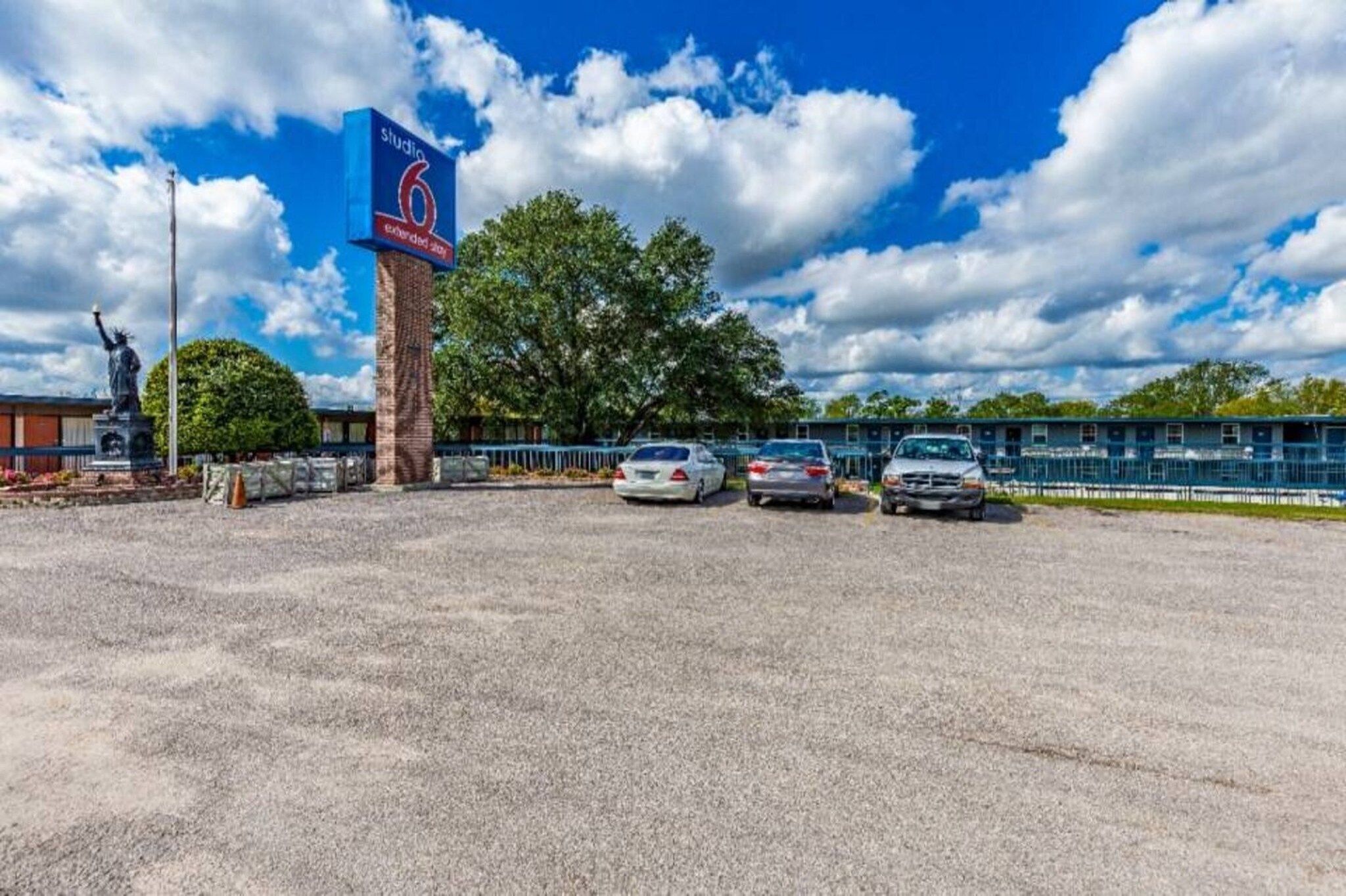 Un parking avec un panneau indiquant « Studio 6, séjours de longue durée ».