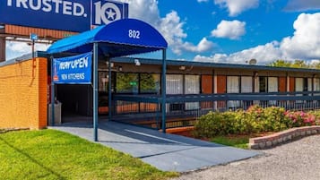 Un hôtel avec un auvent bleu, une enseigne indiquant la présence de nouvelles cuisines et le numéro 802 sur le bâtiment.