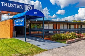 Un hôtel avec un auvent bleu, une enseigne indiquant la présence de nouvelles cuisines et le numéro 802 sur le bâtiment.