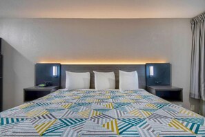 A hotel room with a large bed, two bedside tables, and a headboard with integrated lighting. - 1 King Bed | Mobil Access Tub Nsmk Kitchen (Rosenberg)