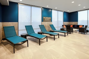 Zona d'espera amb seients relaxants, taulell de recepció i grans finestres.