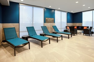 Un área de espera con sillones reclinables, una mesa de recepción y amplios ventanales.