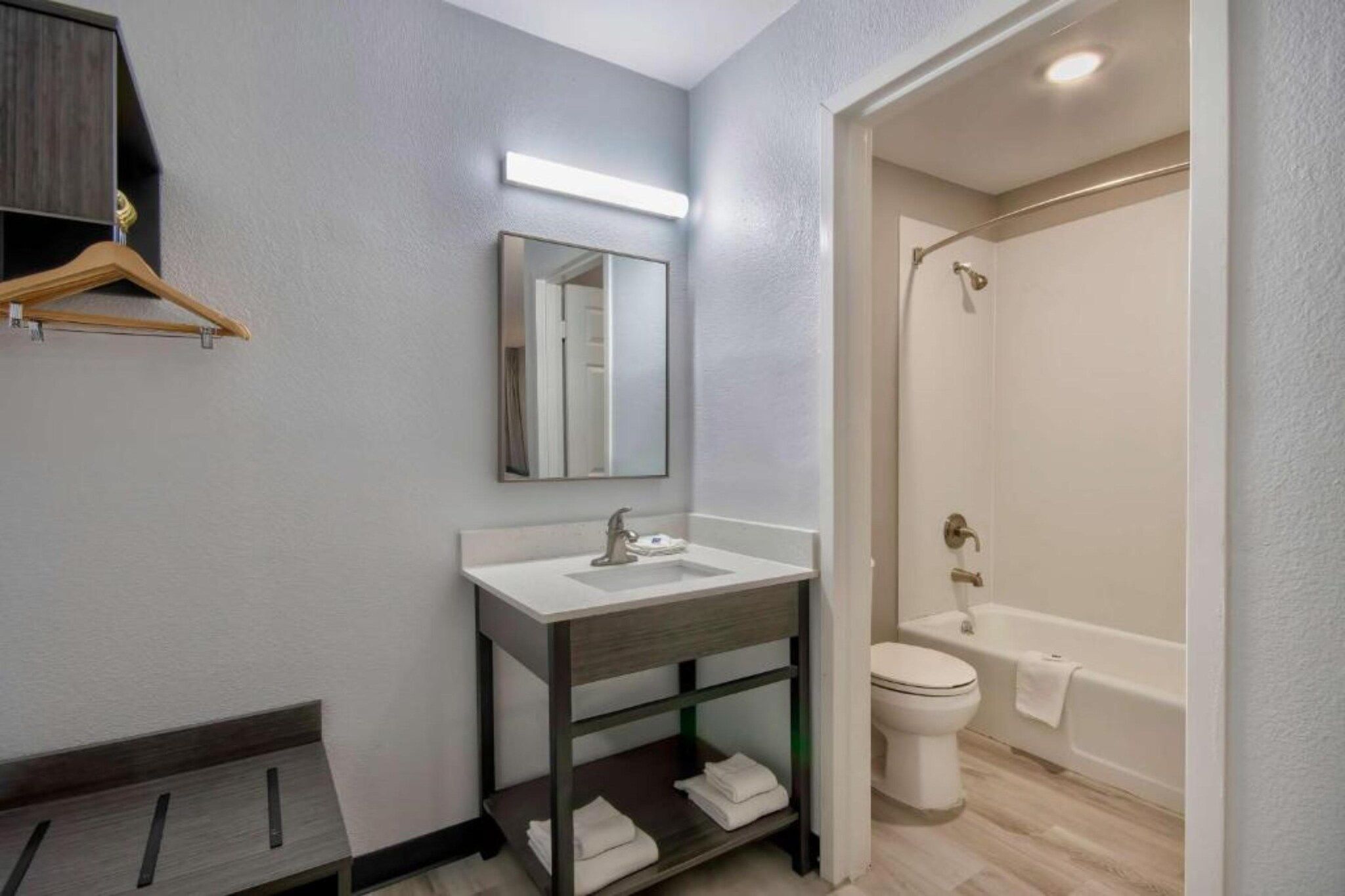 Une salle de bain moderne avec un lavabo, un miroir et un espace douche.