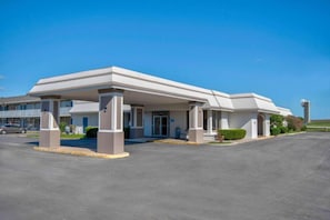 A modern hotel with a covered entrance, a parking lot, and a clear blue sky. - Cozy 2 Full Beds | Nsmk, Kitchen (Rosenberg)