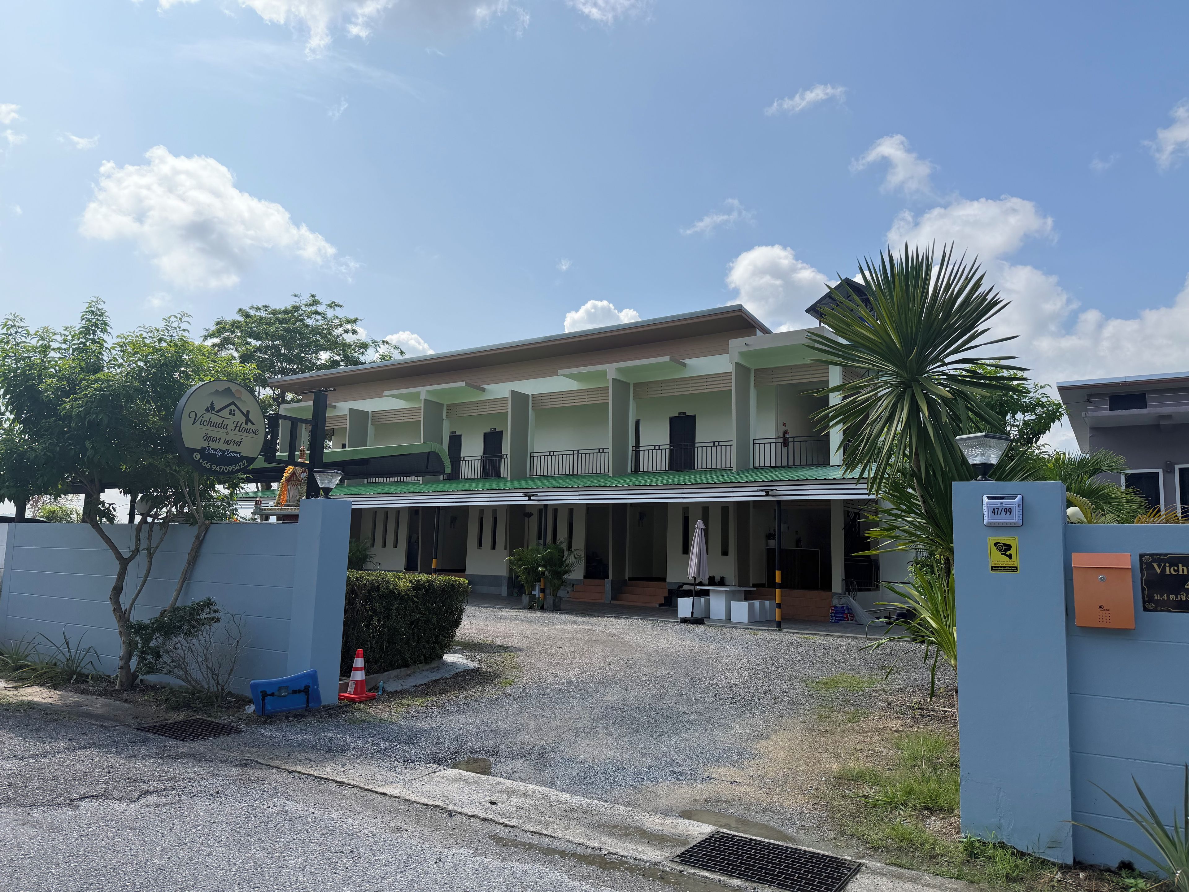 A two-story building with a covered entrance and a balcony.
