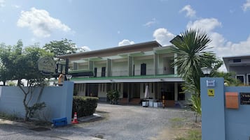 A two-story building with a covered entrance and a balcony.