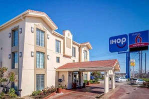 A hotel with a covered entrance, a parking lot, and a sign for I-HOP 6 extended stay. - 2 Full Beds | Non-Smoking, Kitchen (WHITE SETTLEMENT)