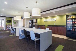 A modern indoor space with a reception area, a counter with chairs, a vending machine, and a sign that reads 'WIFI STUDIO'. - 1 Twin Bed | Mobil Access Tub Nsmk Micfridg (Plano)