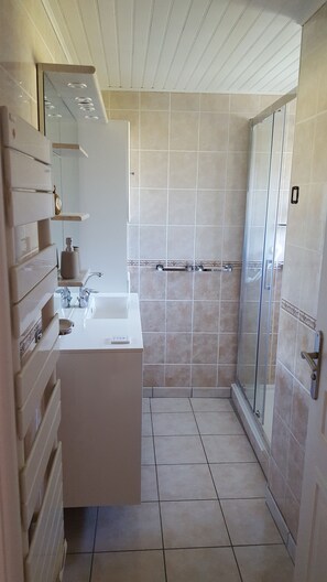 A bathroom with a white sink, mirror, and towel rack. - Holiday Home 'Ty Prawine' with Terrace, Garden and Wi-Fi (Quistinic)