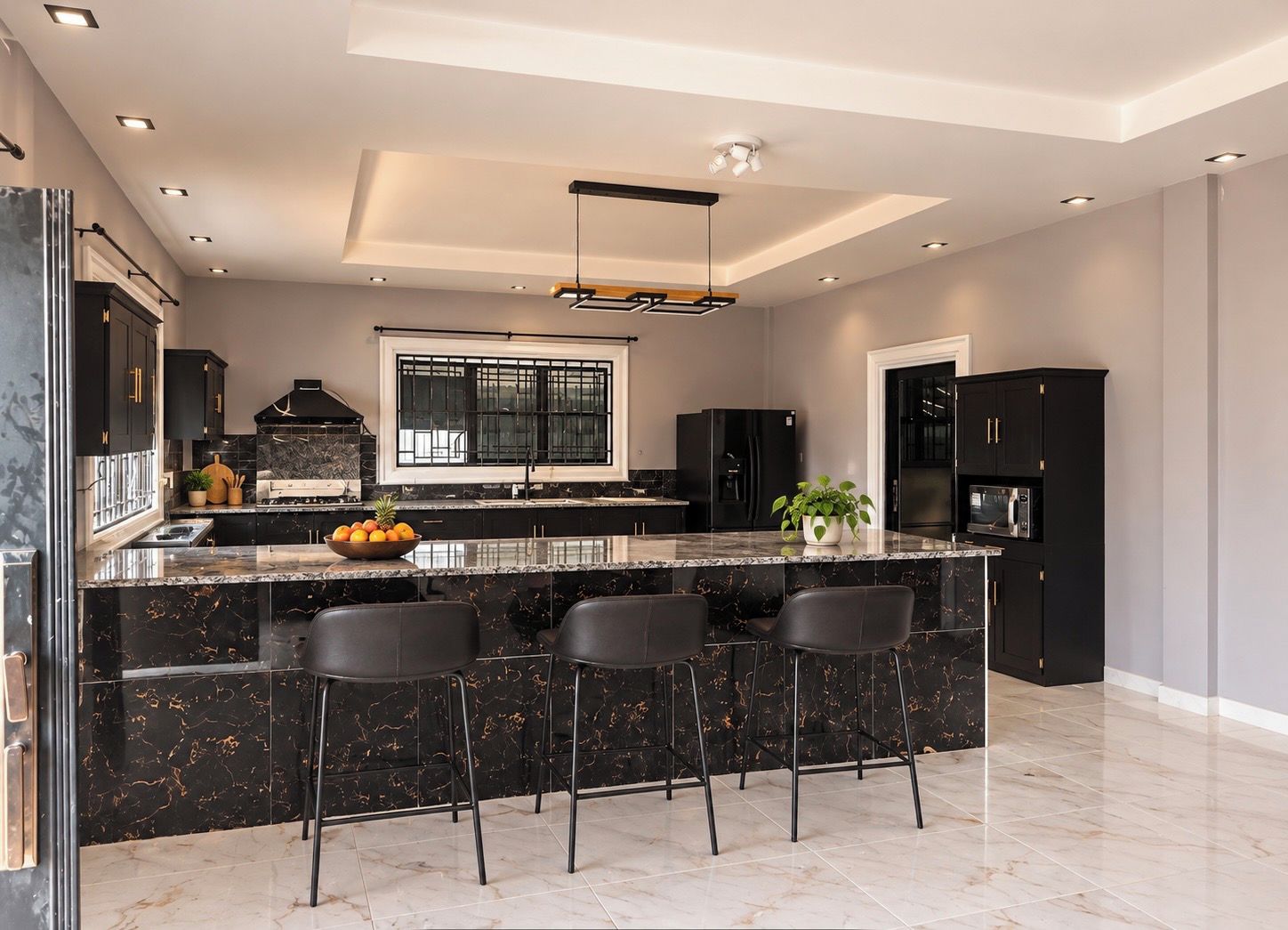 Een moderne keuken met een groot schiereiland, barstoelen en een inbouwoven.