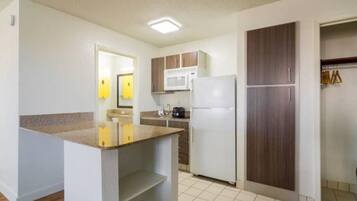 A compact kitchen with a microwave, refrigerator, and a small countertop.