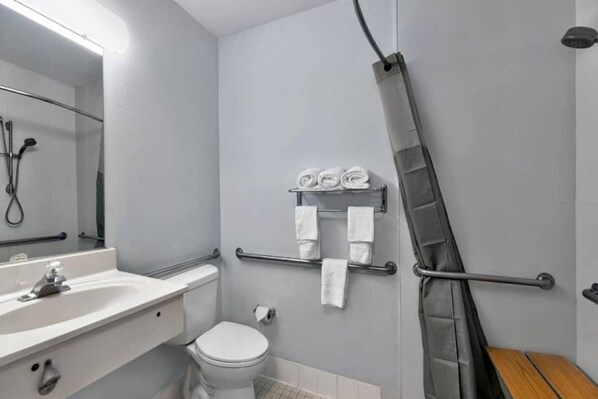 Un bagno moderno con lavandino, WC e doccia bianchi.
