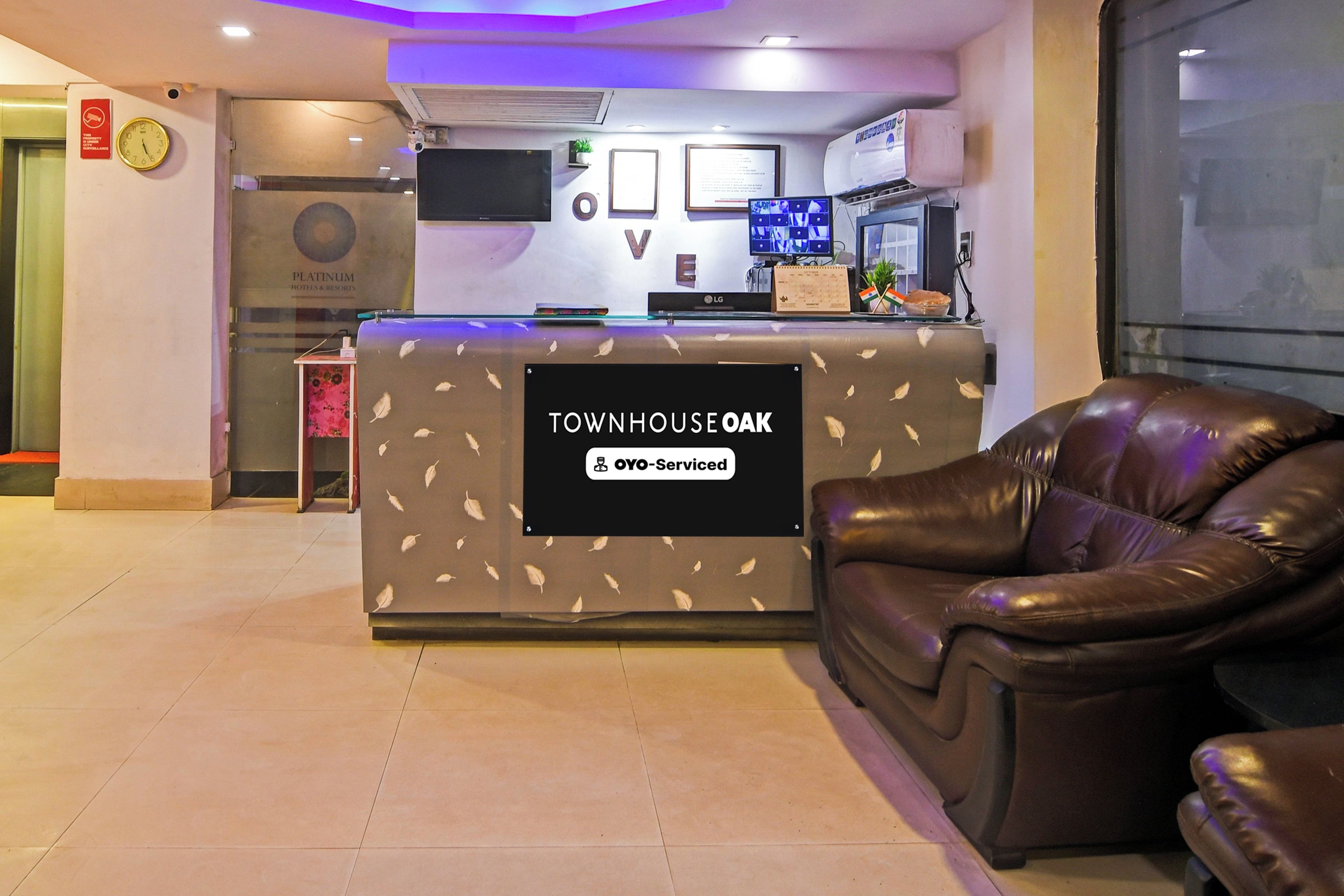 Una recepción con un cartel que dice 'TOWNHOUSE OAK' y 'OYO-Serviced'.