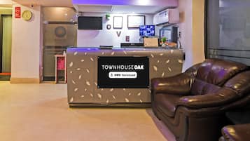 Una recepción con un cartel que dice 'TOWNHOUSE OAK' y 'OYO-Serviced'.
