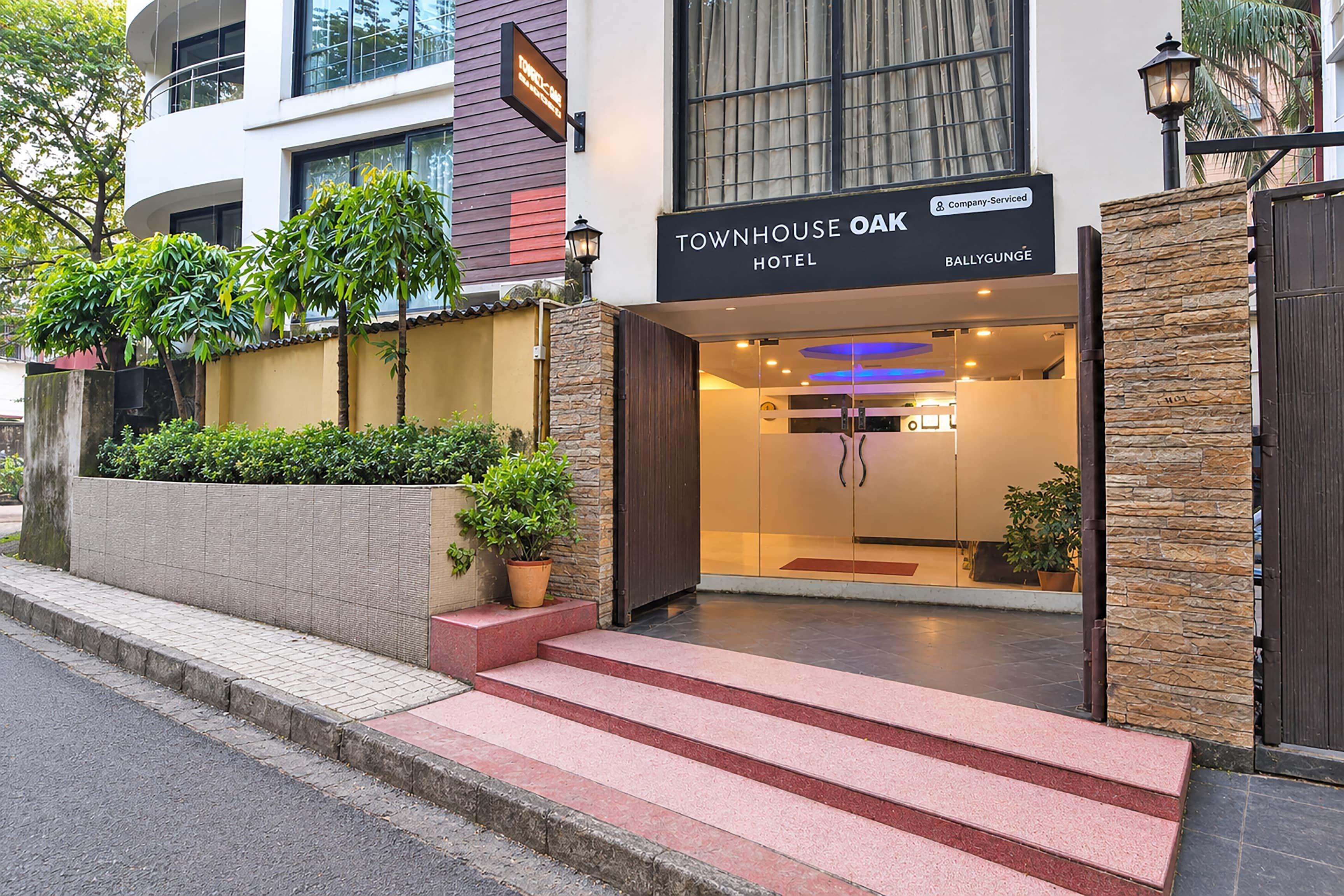 Una entrada de hotel moderna con un cartel que dice 'Townhouse Oak Hotel'.