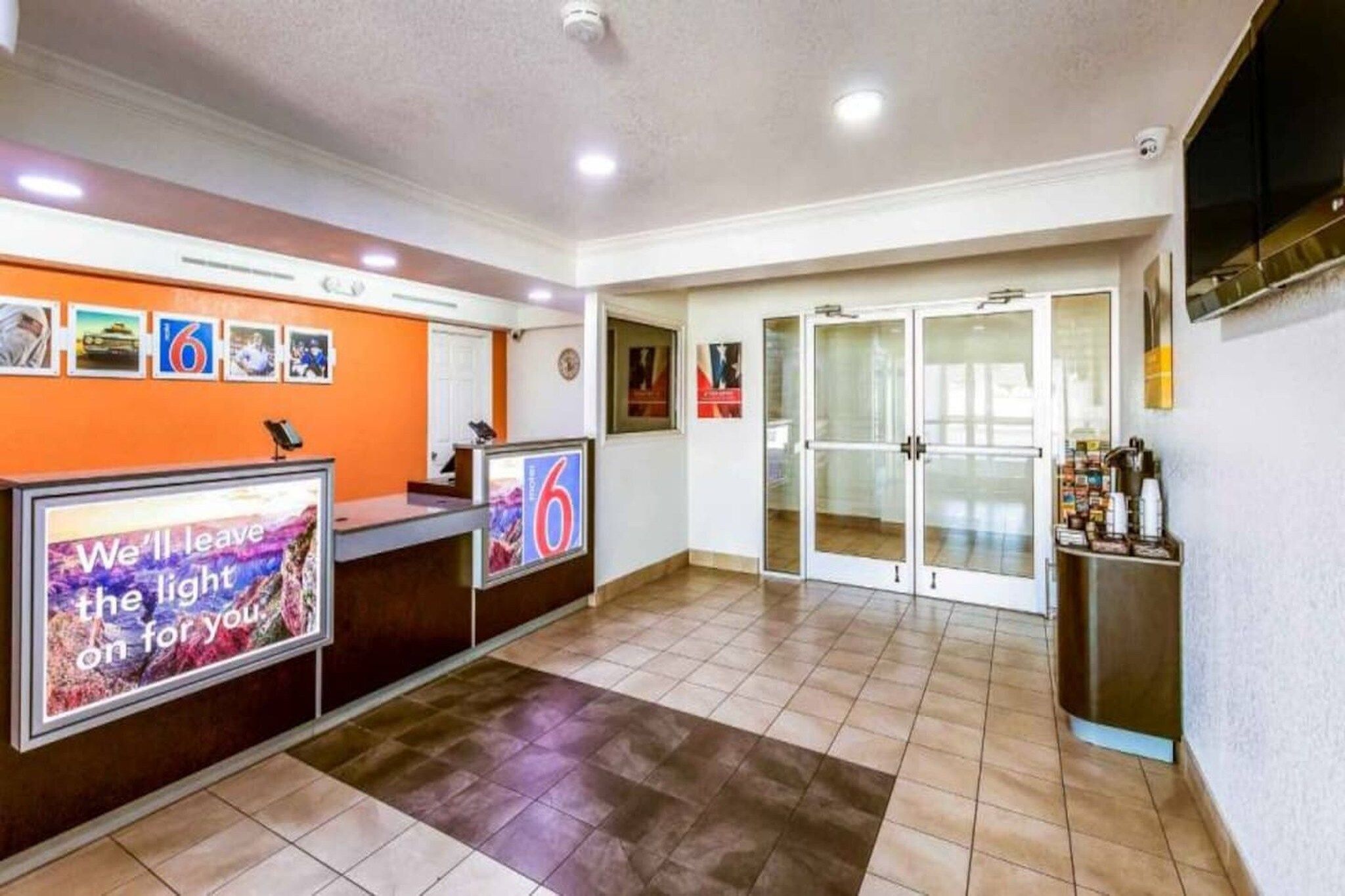 A reception area with a counter, a wall-mounted sign, and a tiled floor.