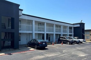 A multi-story motel with a parking lot. - 1 King Bed | Non-Smoking, Kitchen (Fort Worth TX)