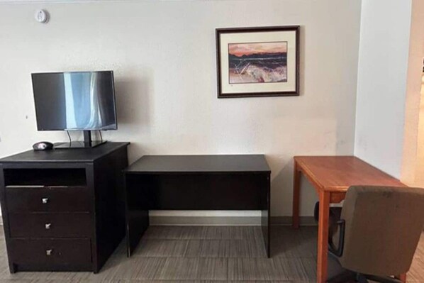 A room with a desk, a chair, a dresser, and a framed picture on the wall. - 1 King Bed | Non-Smoking, Kitchen (Fort Worth TX)