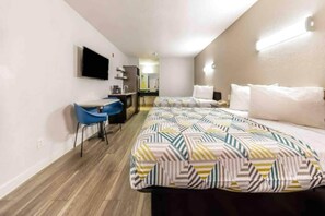 A hotel room with a bed, a desk, a chair, and a television. - 2 FULL BEDS | SMOKING (Fort Worth)