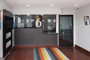 A reception area with a large number '6' sign, a glass door, and a colorful striped carpet. - 1 King Bed | Nsmk, Micfridge (Red Oak)