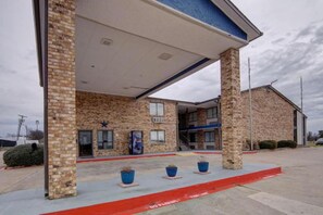 A building with a brick facade, a covered entrance, and a red curb indicating no parking. - 1 King Bed | Nsmk, Micfridge (Red Oak)