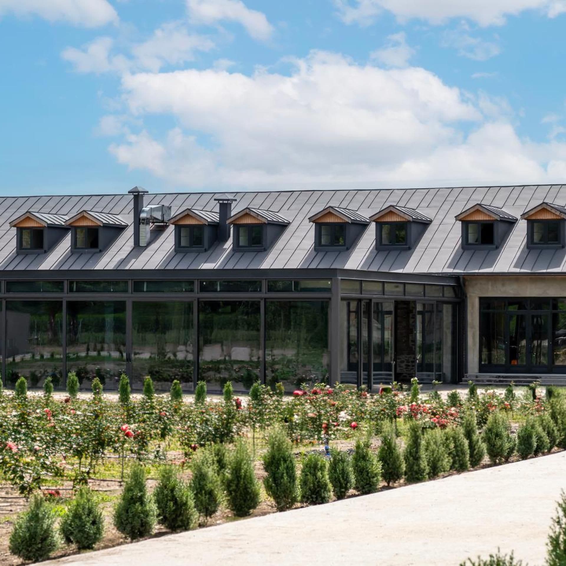 Un bâtiment moderne doté d’un toit plat, de nombreuses fenêtres de toit et d’une façade en verre.
