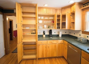 A kitchen with wooden cabinets, a coffee maker, and a countertop. - Spacious & Fun Family Home in the Heart of Emporia (Emporia)