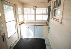 A room with a wooden ceiling, a window with a view, a door, and a small cabinet. - Spacious & Fun Family Home in the Heart of Emporia (Emporia)
