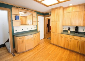 A kitchen with wooden cabinets, a countertop, and a coffee maker. - Spacious & Fun Family Home in the Heart of Emporia (Emporia)