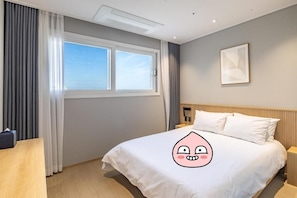 A hotel room with a bed, a desk, and a window with curtains. - Richeville Signature Hotel and Residence (Sokcho)
