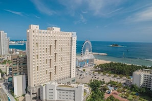 A high-rise hotel with a view of the sea and a Ferris wheel in the background. - Richeville Signature Hotel and Residence (Sokcho)