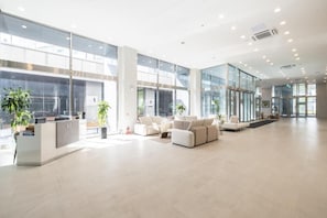 A spacious lobby with a reception desk, seating area, and large windows. - Richeville Signature Hotel and Residence (Sokcho)