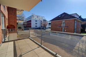 A residential building with a balcony, a brick facade, and a clear view of the street. - Holiday apartment with 2 bedrooms (St. Peter-Ording)