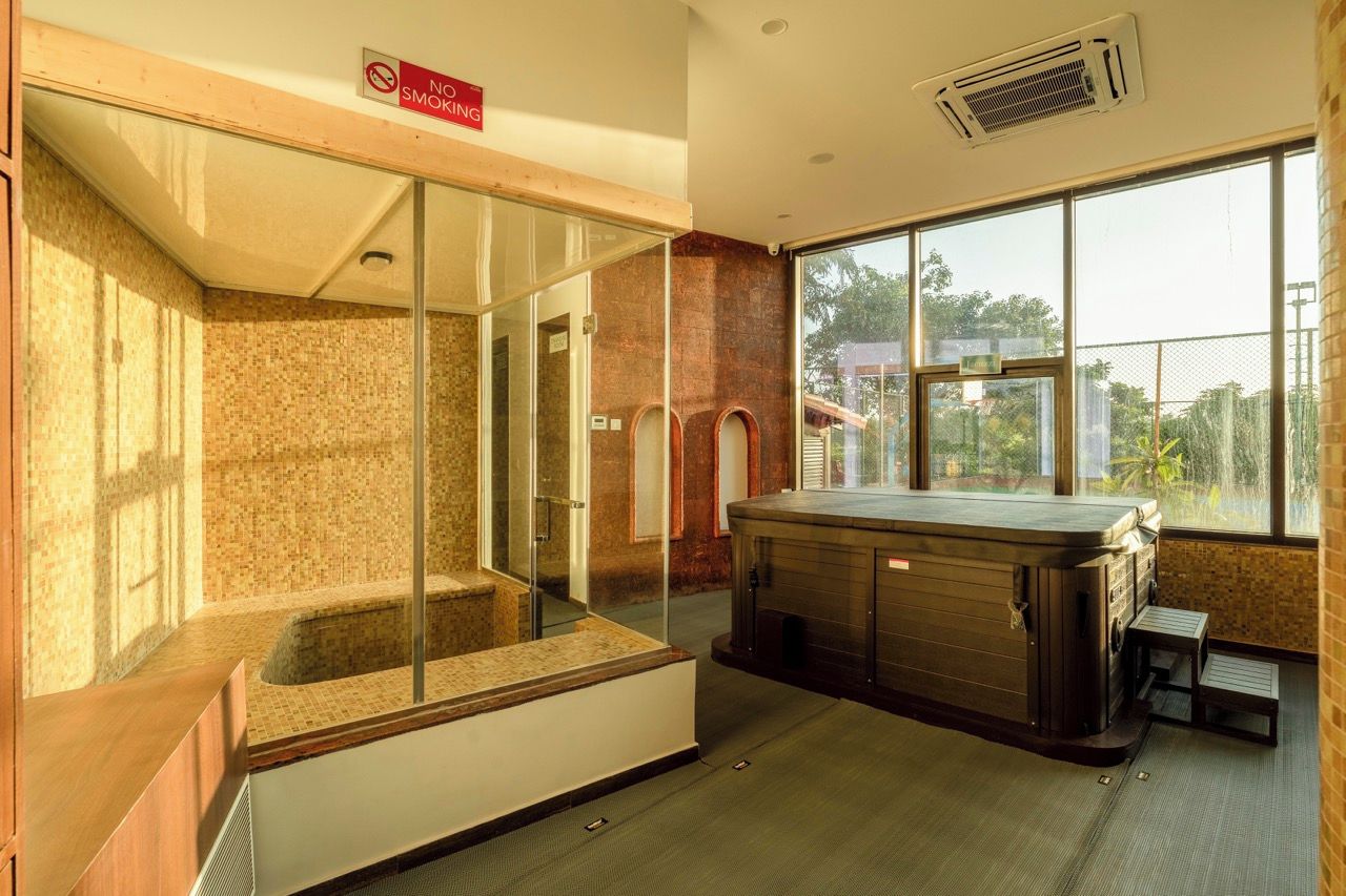Una sauna con cabina in vetro, una vasca idromassaggio e vista panoramica attraverso ampie finestre.