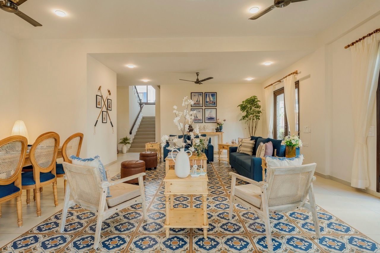A spacious living room with a patterned floor, a coffee table, seating area, and a staircase leading to an upper level.