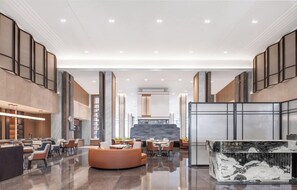 A spacious lobby with a central seating area, a reception desk, and a modern kitchen in the background. - Pullman Taizhou Xianju (Taizhou)