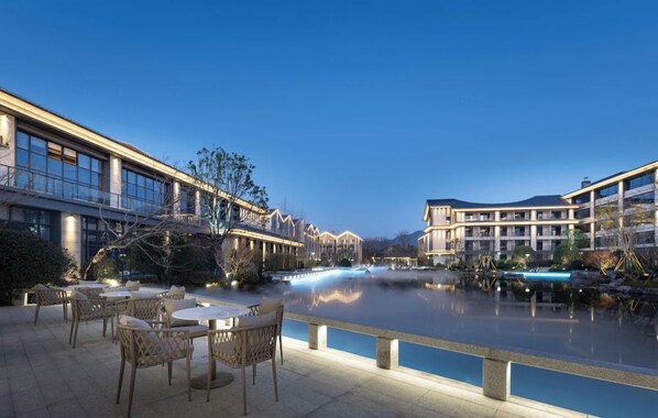 A riverside hotel with outdoor seating and a reflection pool. - Pullman Taizhou Xianju (Taizhou)