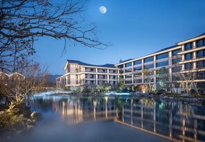 A modern hotel with a reflective pool, a clear night sky, and a full moon. - Pullman Taizhou Xianju (Taizhou)